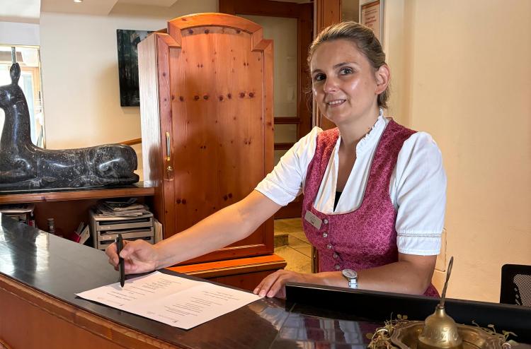 Rezeptionsmitarbeiterin beim Ausfüllen eines Formulars im Romantik Hotel | Restaurant Hirsch auf der Schwäbischen Alb